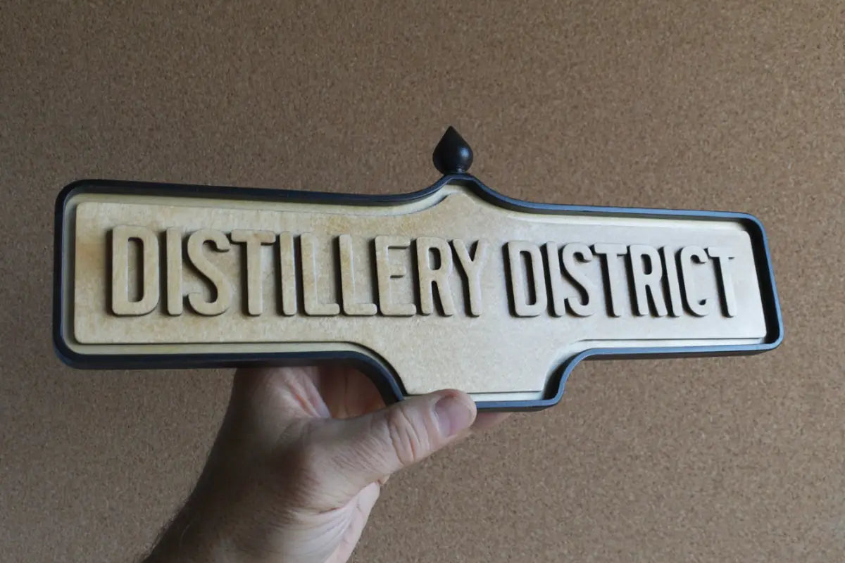 In-hand view of Distillery District Wall Sign - Natural Finish, wall-mounted replica Toronto acorn neighbourhood sign