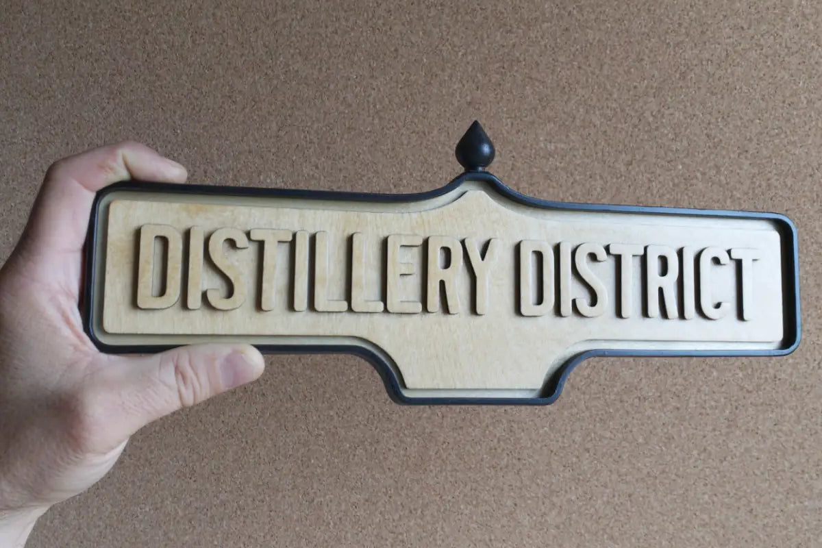 In-hand view of Distillery District Wall Sign - Natural Finish, wall-mounted replica Toronto acorn neighbourhood sign
