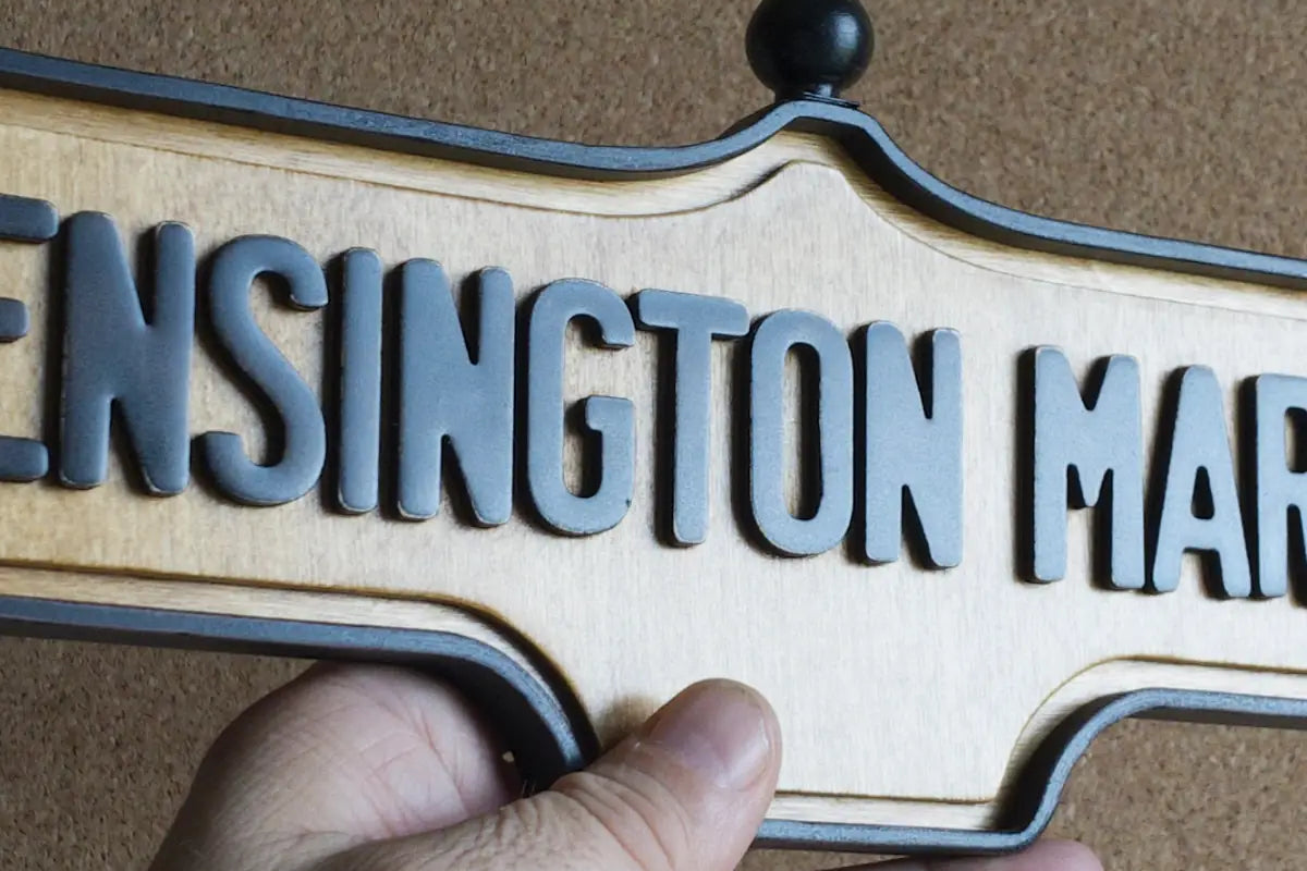 In-hand view of Kensington Market Wall Sign - Natural Finish, wall-mounted replica Toronto acorn neighbourhood sign