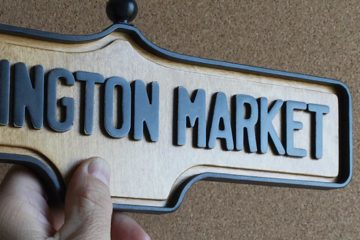 In-hand view of Kensington Market Wall Sign - Natural Finish, wall-mounted replica Toronto acorn neighbourhood sign
