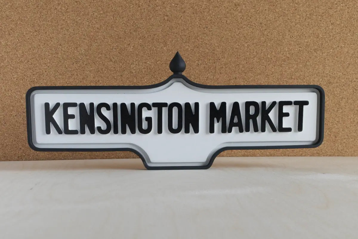 Front view of Kensington Market Wall Sign - Standard Finish, wall-mounted replica Toronto acorn neighbourhood sign