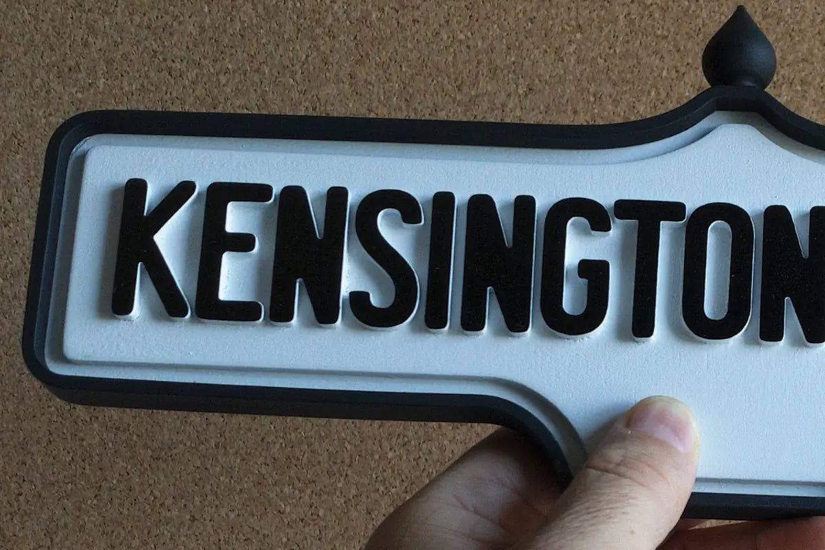 In-hand view of Kensington Market Wall Sign - Standard Finish, wall-mounted replica Toronto acorn neighbourhood sign