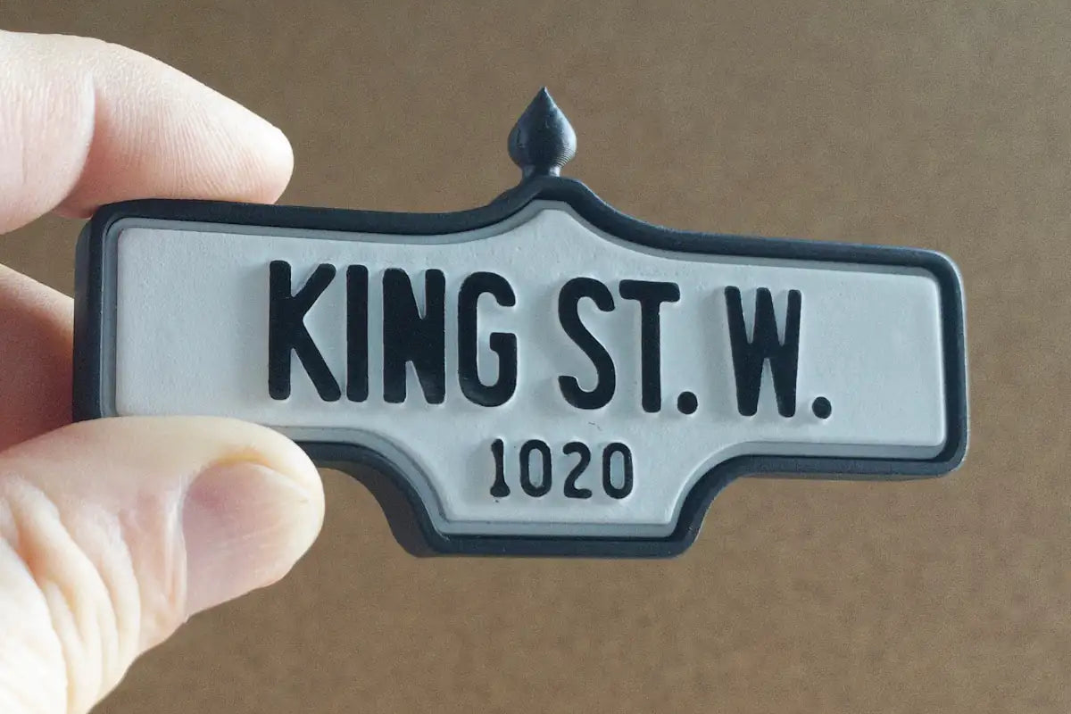 In-hand view of King St. W. #1020 - Standard Finish, miniature replica Toronto acorn street sign