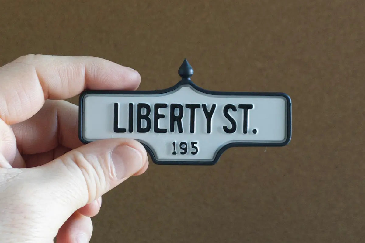 In-hand view of Liberty St. #195 Pin - Standard Finish, miniature replica Toronto acorn street sign