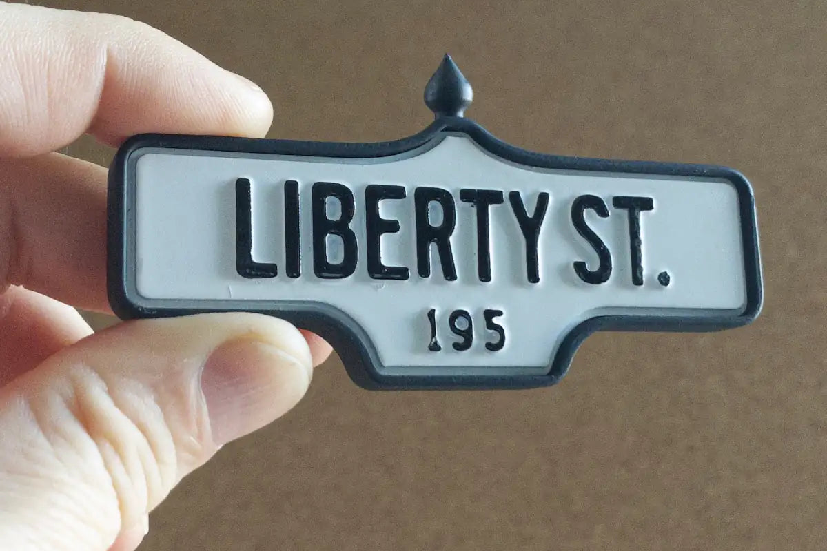 In-hand view of Liberty St. #195 Pin - Standard Finish, miniature replica Toronto acorn street sign