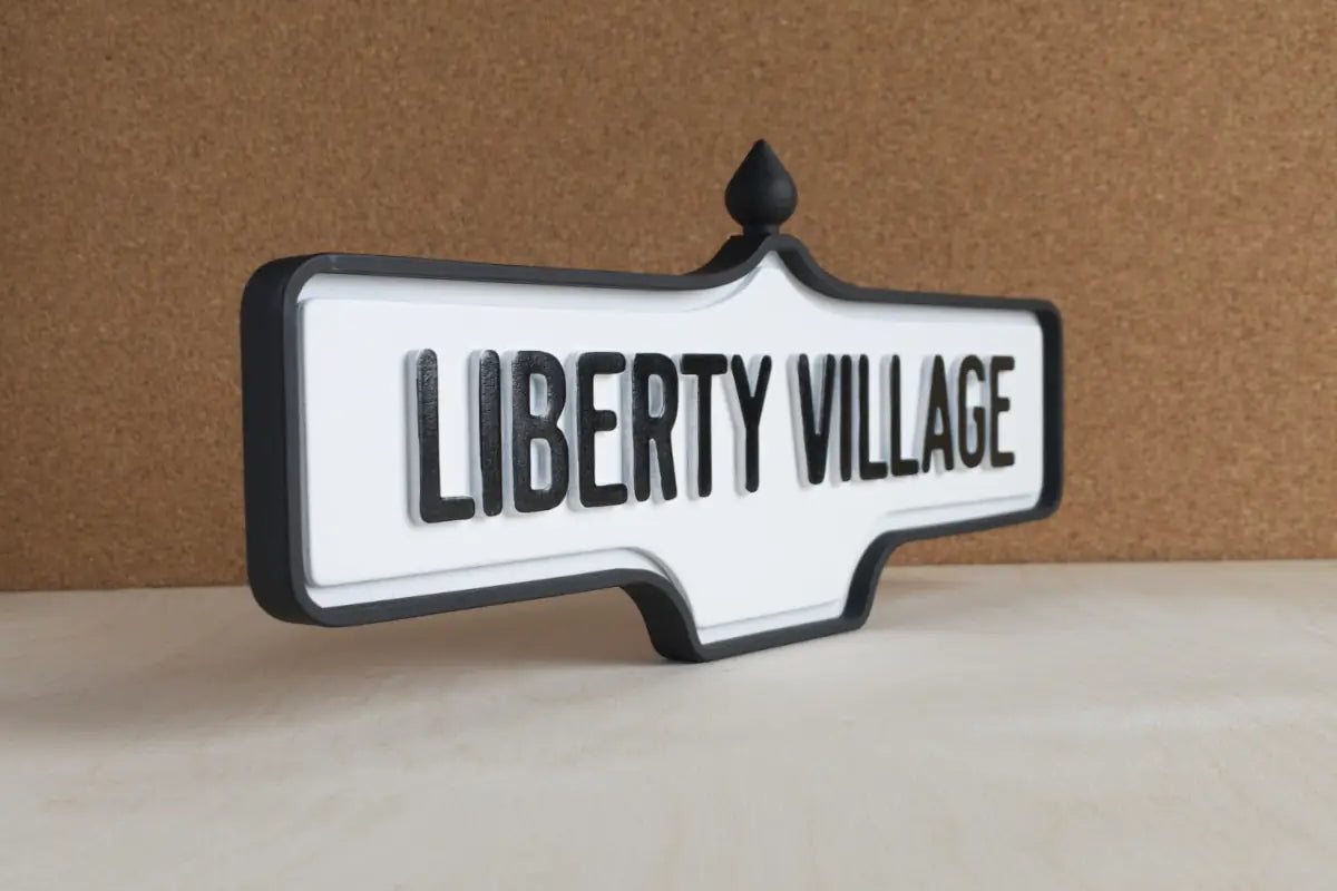Angled front view of Liberty Village Wall Sign - Standard Finish, wall-mounted replica Toronto acorn neighbourhood sign
