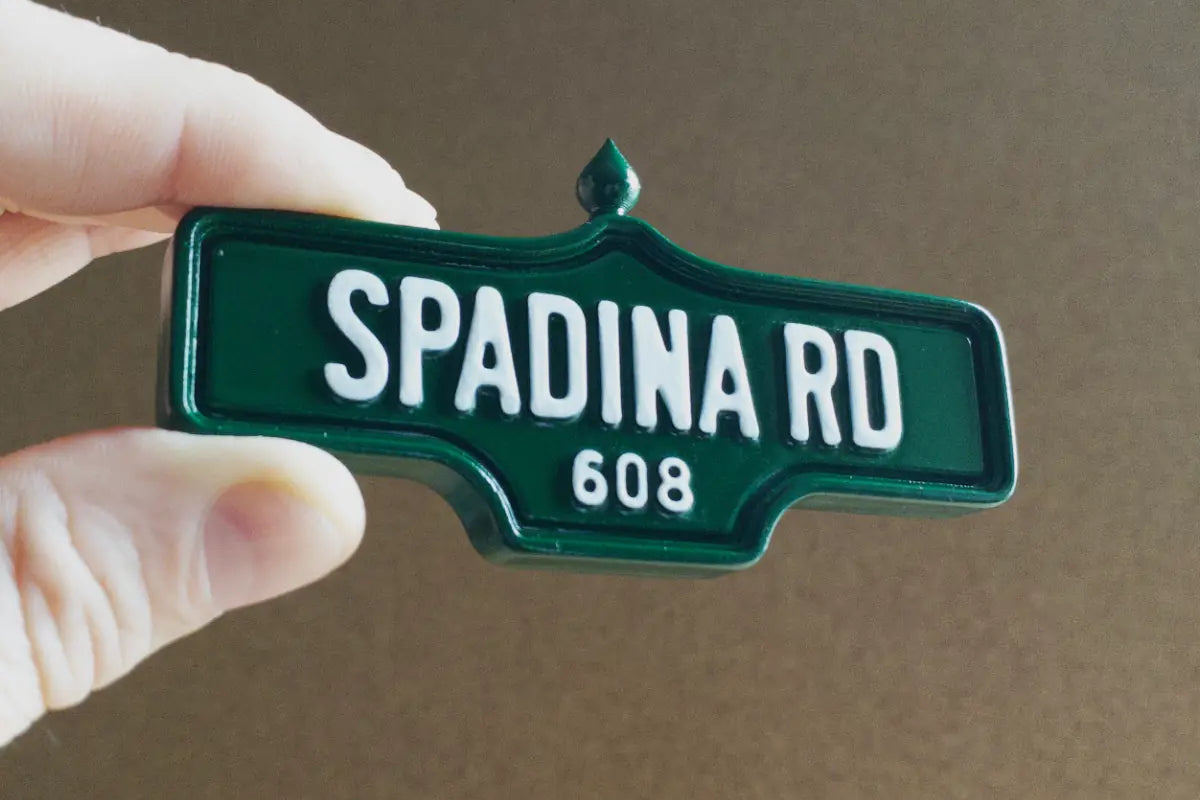 In-hand view of Spadina Rd #608 Magnet - Standard Finish, miniature replica Toronto Forest Hill acorn street sign