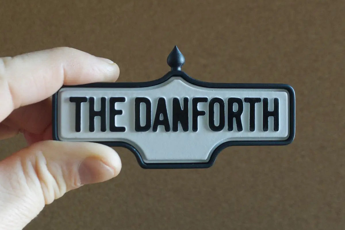 In-hand view of The Danforth - Standard Finish I, miniature replica Toronto neighbourhood acorn street sign