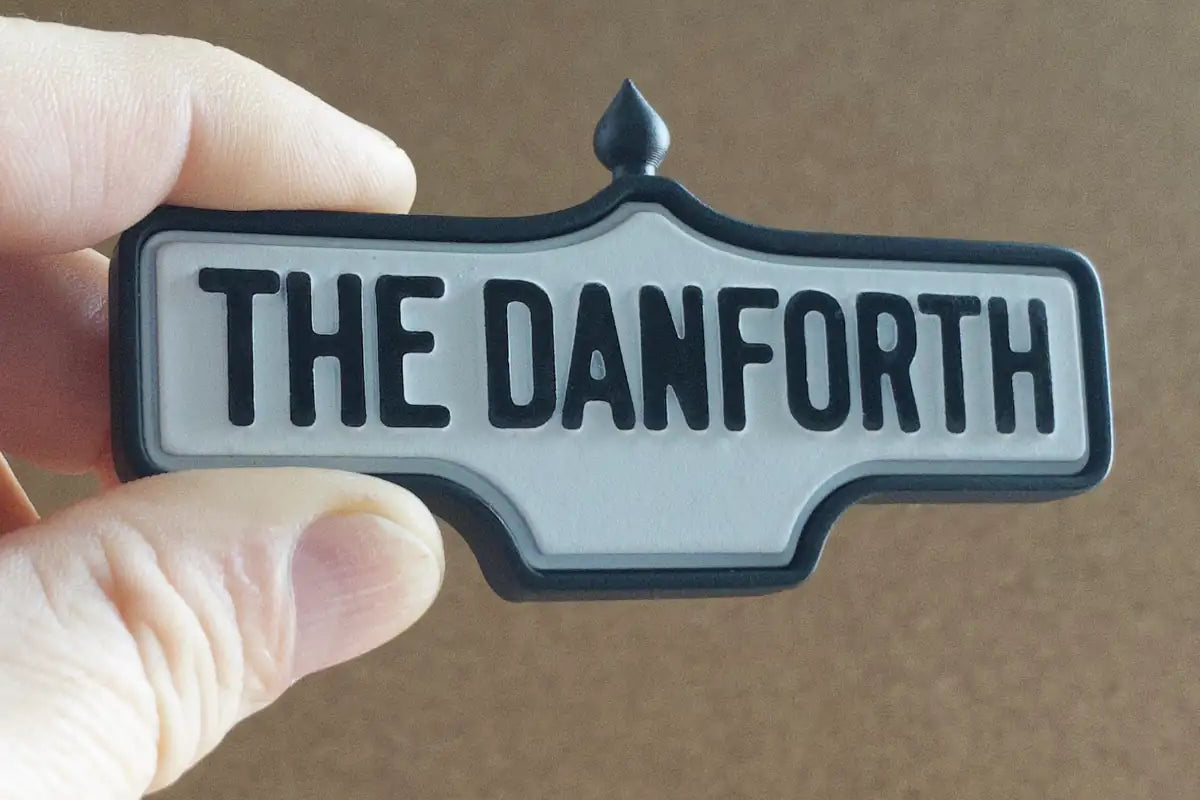 In-hand view of The Danforth - Standard Finish I, miniature replica Toronto neighbourhood acorn street sign