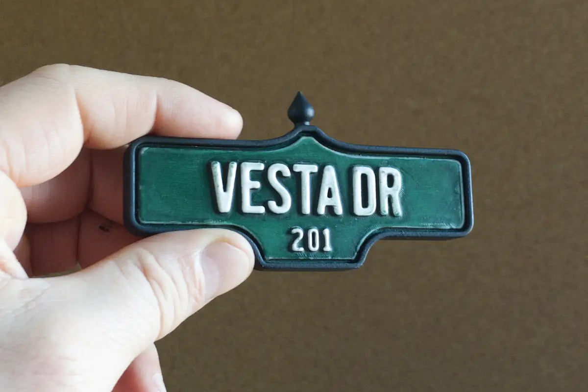 In-hand view of Vesta Dr #201 Magnet - Weathered Finish, miniature replica Toronto Forest Hill acorn street sign