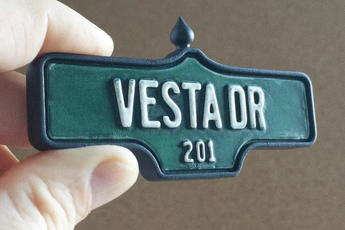 In-hand view of Vesta Dr #201 Magnet - Weathered Finish, miniature replica Toronto Forest Hill acorn street sign